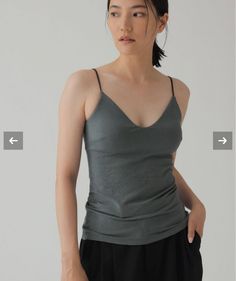 Woman in a gray camisole and black pants in a studio setting