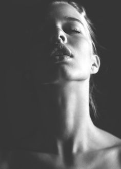 Black and white portrait of a woman with closed eyes and dramatic lighting