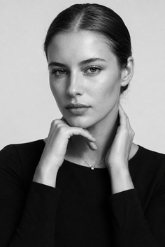 Woman with pulled back hair and a simple necklace in a black and white portrait