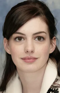 Woman with dark brown hair and brown eyes in a white collared top