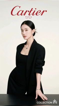 Woman in a black blazer and jewelry posing in a studio
