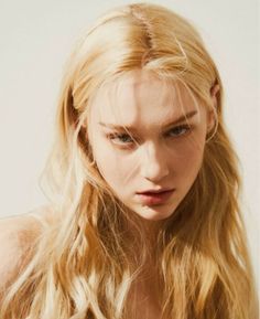 Close up portrait of a woman with long blonde wavy hair and soft lighting