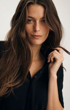 Woman with long brown hair and blue eyes wearing a black shirt