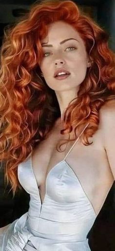 Woman with long red curly hair in a white dress with cleavage