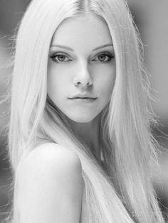 Woman with long blonde hair in a black and white portrait with exposed shoulders