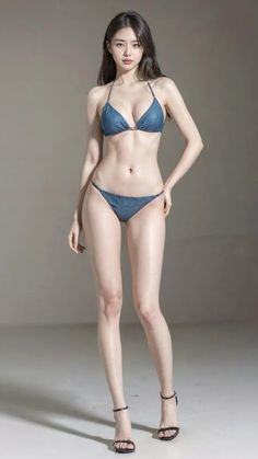 Woman in a blue bikini and high heels posing indoors