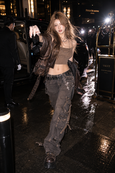 Woman in a crop top and cargo pants at night with dramatic lighting