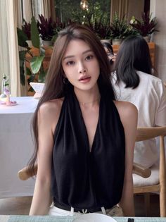 Woman with long hair wearing a black deep V-neck top indoors
