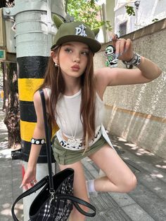 Young woman in a green cap and mini skirt posing on a street