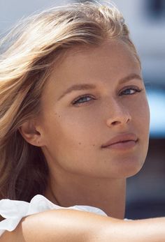 Blonde woman with blue eyes and long hair in soft outdoor lighting