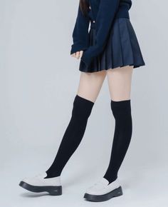 Person in a school uniform with a pleated skirt and thigh-high socks
