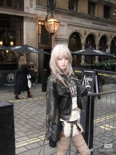Woman with blonde hair in a leather jacket and mini skirt on a street