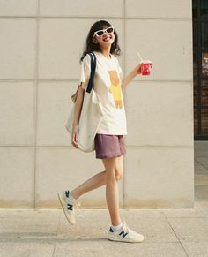 Young woman in a white t-shirt and purple shorts walking outdoors