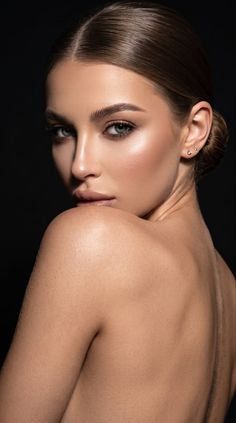 Woman with bare shoulders and an updo looking over her shoulder