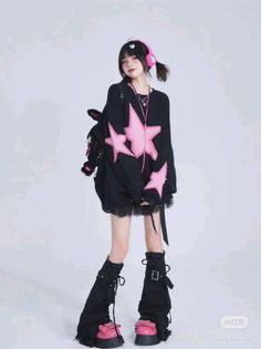 Person in an oversized black sweater with pink stars and pink platform shoes