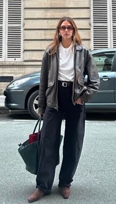 Woman in a leather jacket and wide leg pants on a city street