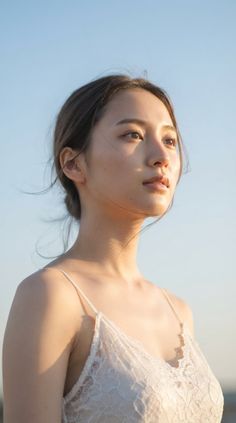 Woman in a white lace top looking up at golden hour