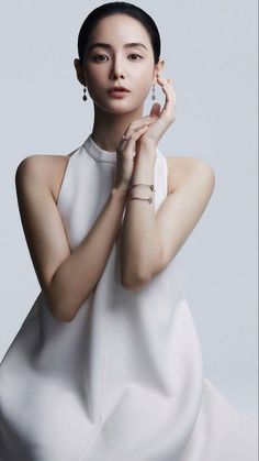 Woman in a white dress with jewelry posing in a studio