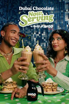 Two people toasting with milkshakes and pancakes at a restaurant