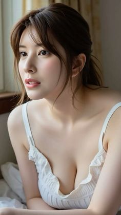 Woman in a white top with cleavage, looking away with soft lighting