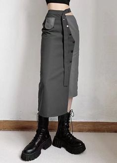 Person wearing a dark midi skirt with an asymmetrical design and black boots