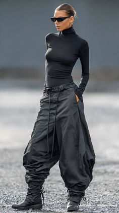 Woman in a black turtleneck and baggy pants with sunglasses outdoors