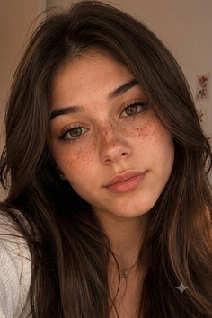 Close up portrait of a young woman with freckles and long brown hair