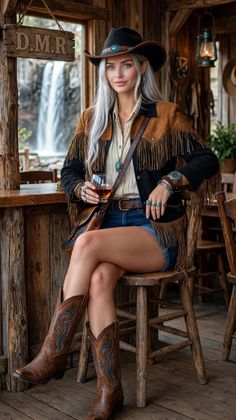 Woman in cowboy attire sitting at a bar with a waterfall view