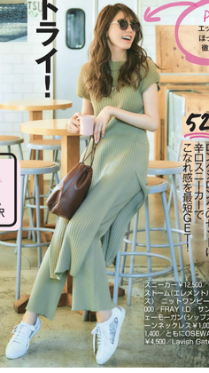 Woman in a ribbed knit dress and sneakers sitting on a stool indoors