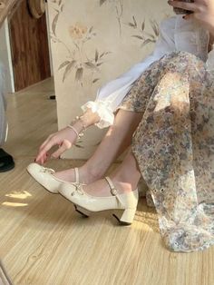 Person wearing a floral dress and mary jane shoes indoors