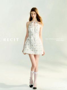 Woman in a white floral halter dress and white socks posing in a studio
