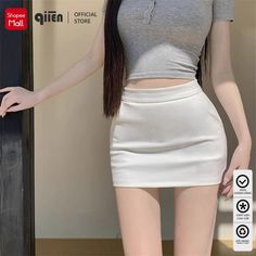Woman in a white mini skirt and grey crop top with long dark hair