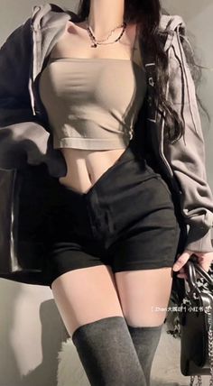 Woman in a crop top, hoodie, and shorts with thigh high socks