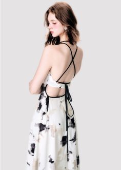 Woman with long hair wearing an open back dress and a black choker