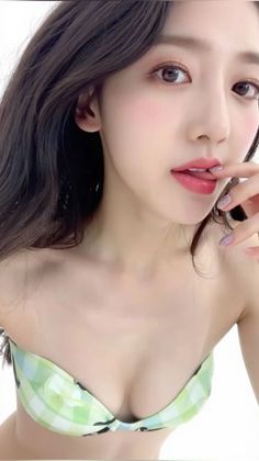 Woman in a green plaid bikini top with a finger on her lips