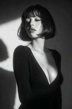 Woman with short hair and a deep V-neck top in dramatic black and white lighting