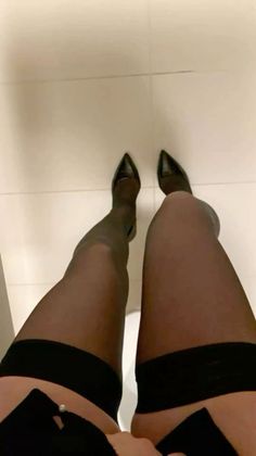 Person wearing black stockings and high heels from a low angle perspective