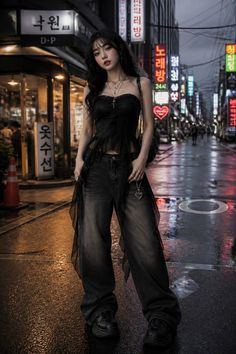 Woman in a black strapless top and wide leg jeans on a wet street at night