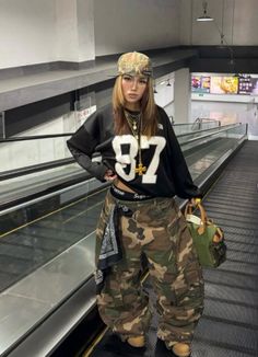 Woman in a baseball cap and camo pants on an escalator
