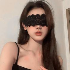 Woman with a black lace blindfold and long hair, wearing a black top