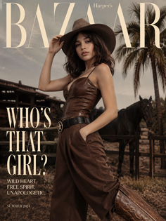 Woman in a cowboy hat and leather top with a horse in the background