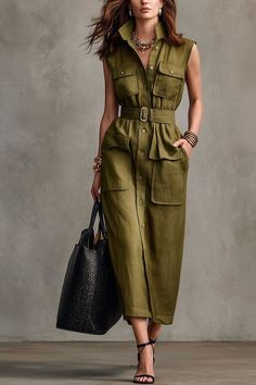 Woman in an olive green belted dress holding a black handbag