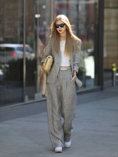 Woman in a pinstripe suit and crop top walking outdoors