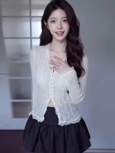 Woman with long dark hair wearing a white sheer blouse and black skirt indoors