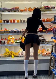Woman in a black top and mini skirt shopping in a supermarket