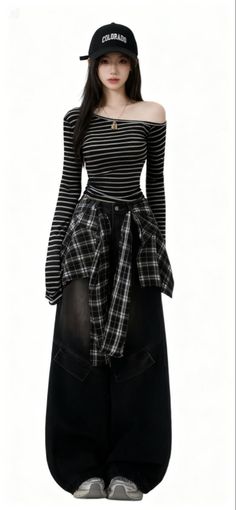 Woman in a baseball cap, striped shirt, plaid shirt, and baggy pants