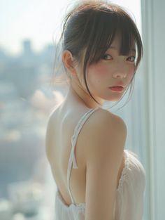 Woman in a white dress with an exposed back looking over her shoulder