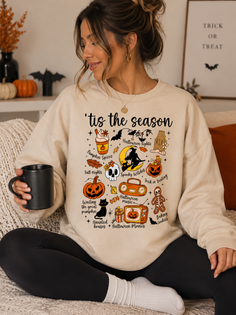 Woman in a Halloween-themed sweater holding a mug indoors