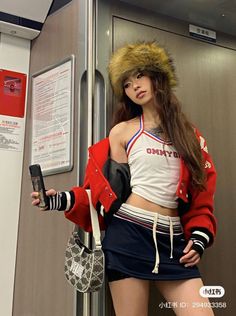 Woman in a fur hat, red jacket, and crop top in a subway car