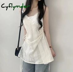Woman in a white lace top and jeans with a shoulder bag